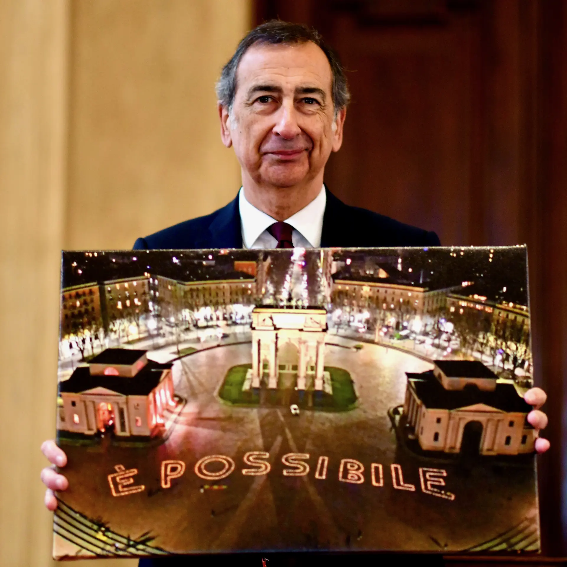 Il Sindaco Giuseppe Sala mostra una foto con l'Arco della pace e la scritta è possibile